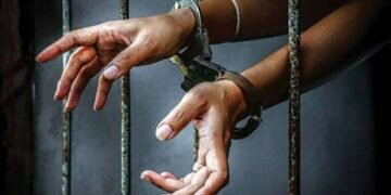 Hands on handcuffs in police cell to portray tragic incident